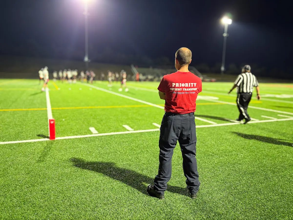 Paramedic standing on the sideline of a high school football game